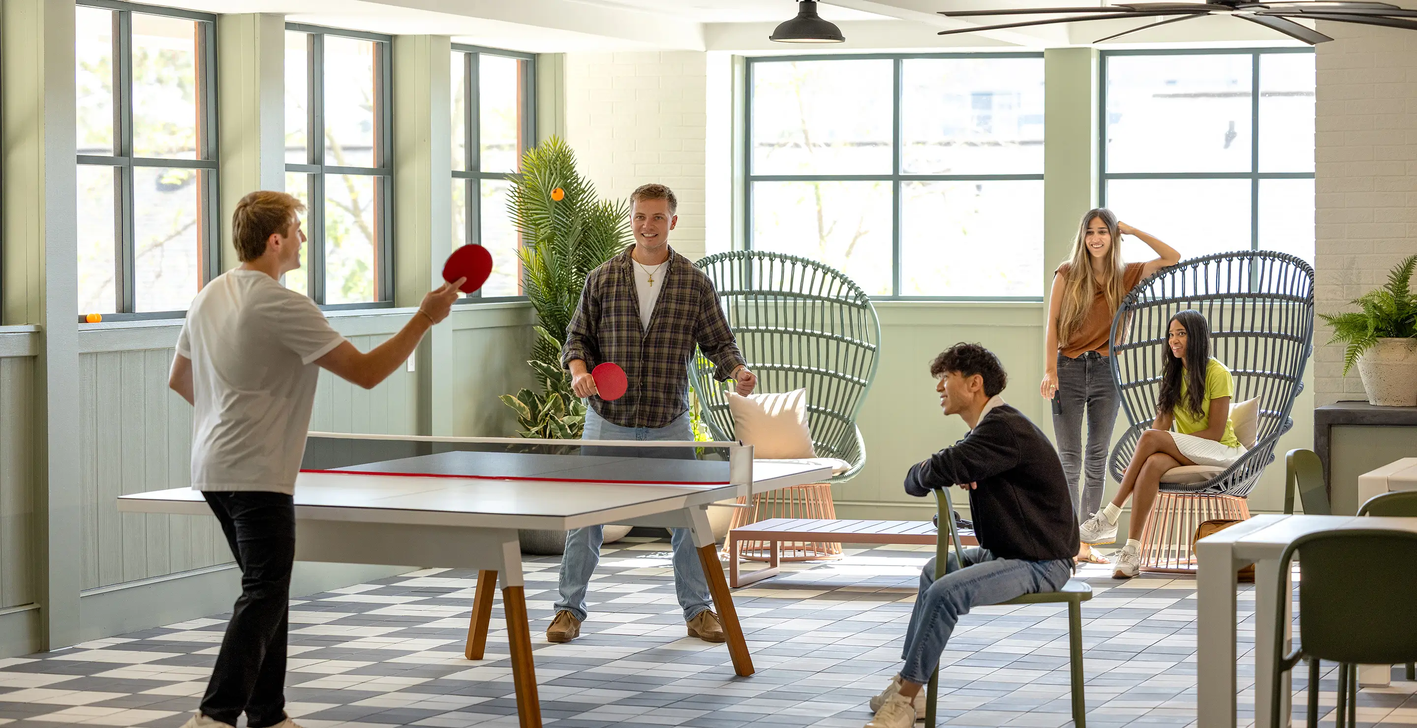 group of young adults playing ping pong